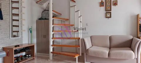 Dnevna soba sa bež kaučem i kružnim stepeništem koje vodi na sprat. - image 7