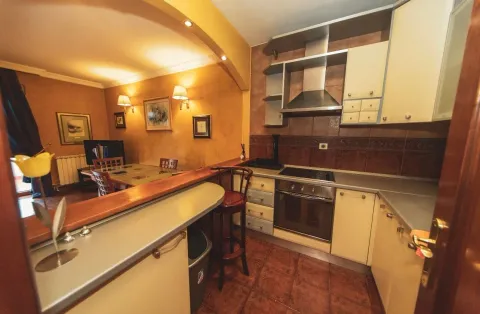 Kitchen equipped with cabinetry featuring a breakfast bar and a dining area in the background. - image 6