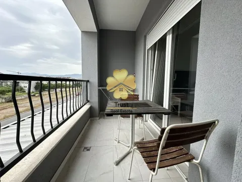 Covered balcony with a table and chairs and a view of the surroundings. - image 6