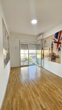 Empty bright room with parquet flooring and large balcony doors. - image 4