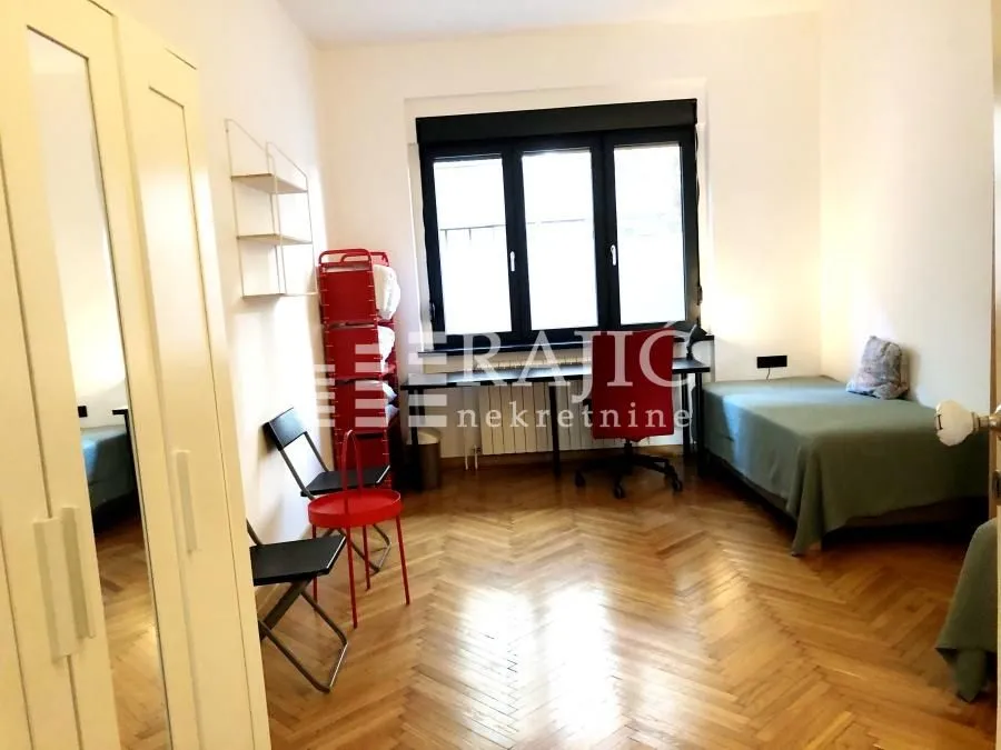 Furnished bedroom with a bed and a window.