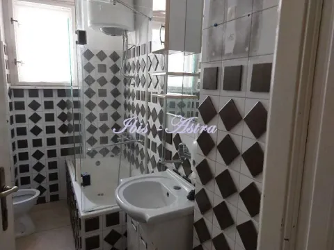 Bathroom with a bathtub, washbasin, and toilet, tiled with black and white tiles. - image 14