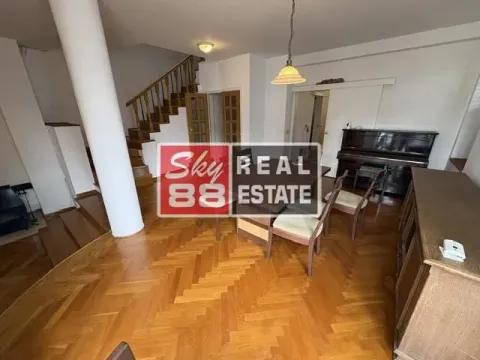 Spacious living room with a dining area, wooden staircase, and parquet flooring. - image 2