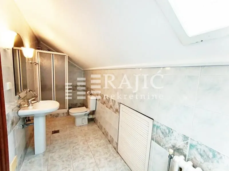 Smaller bathroom with sanitary fixtures and a shower cabin in the attic.