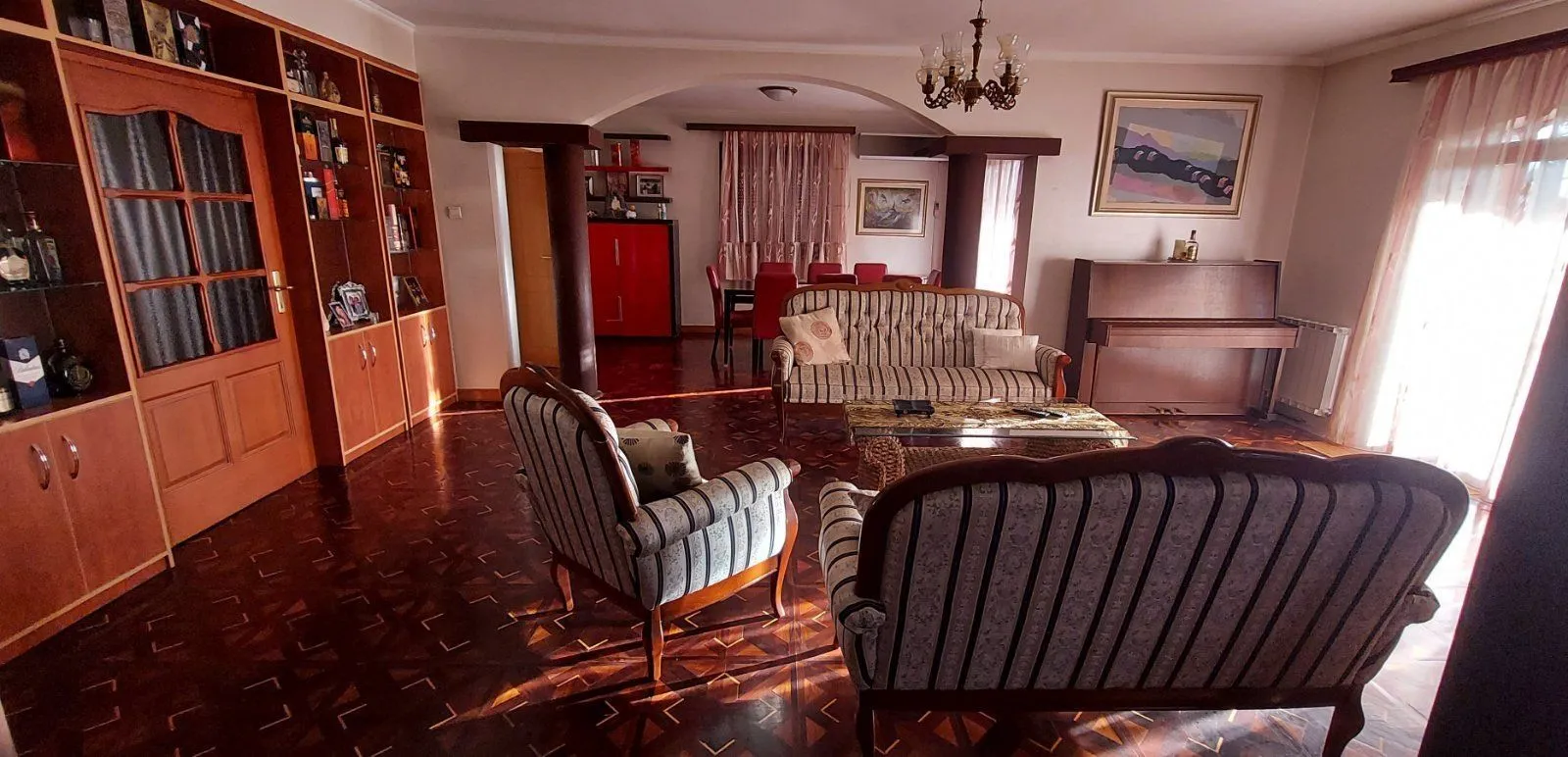 Spacious living room with classic furniture and parquet flooring.