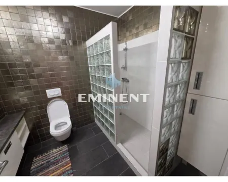 Savremeno opremljeno kupatilo sa tuš kabinom od staklenih blokova i WC šoljom. - image 8