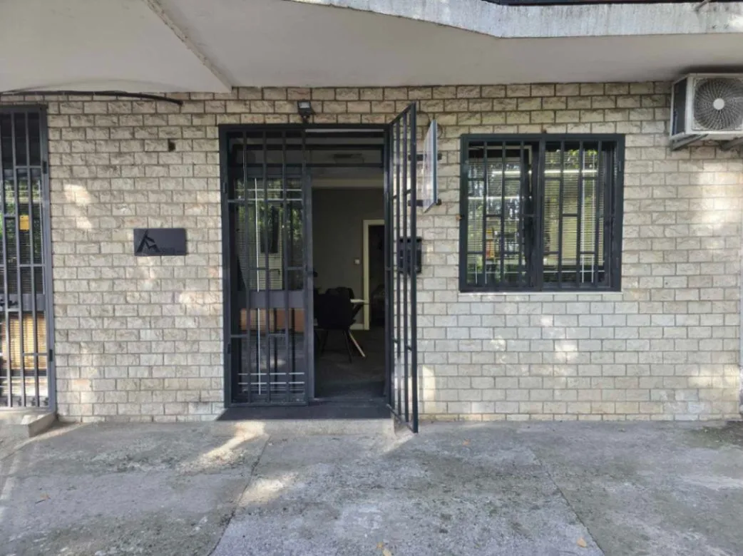 Entrance to a commercial space with a brick facade and security bars.
