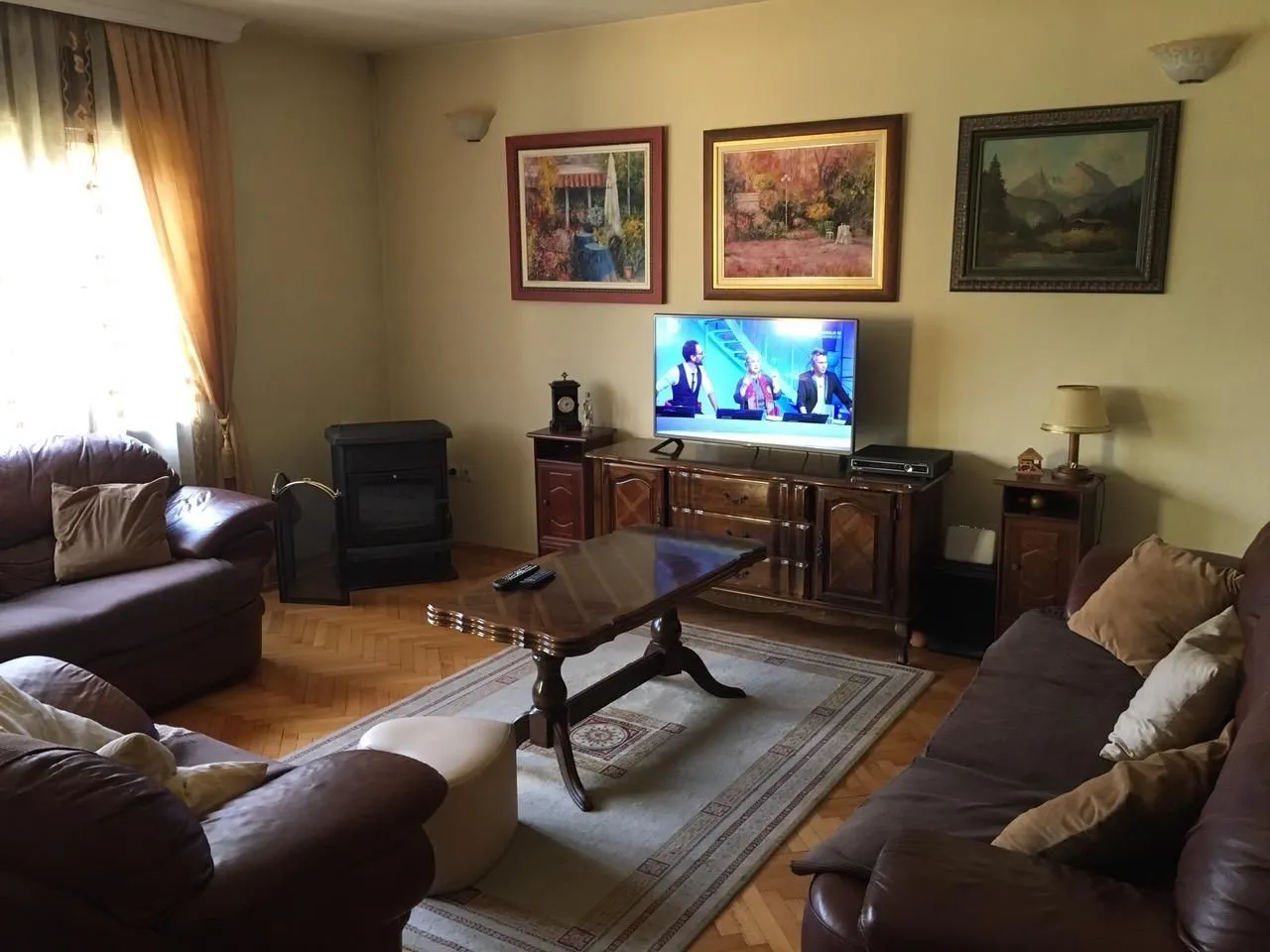 Living room with leather sofas, a wooden coffee table, and a TV.