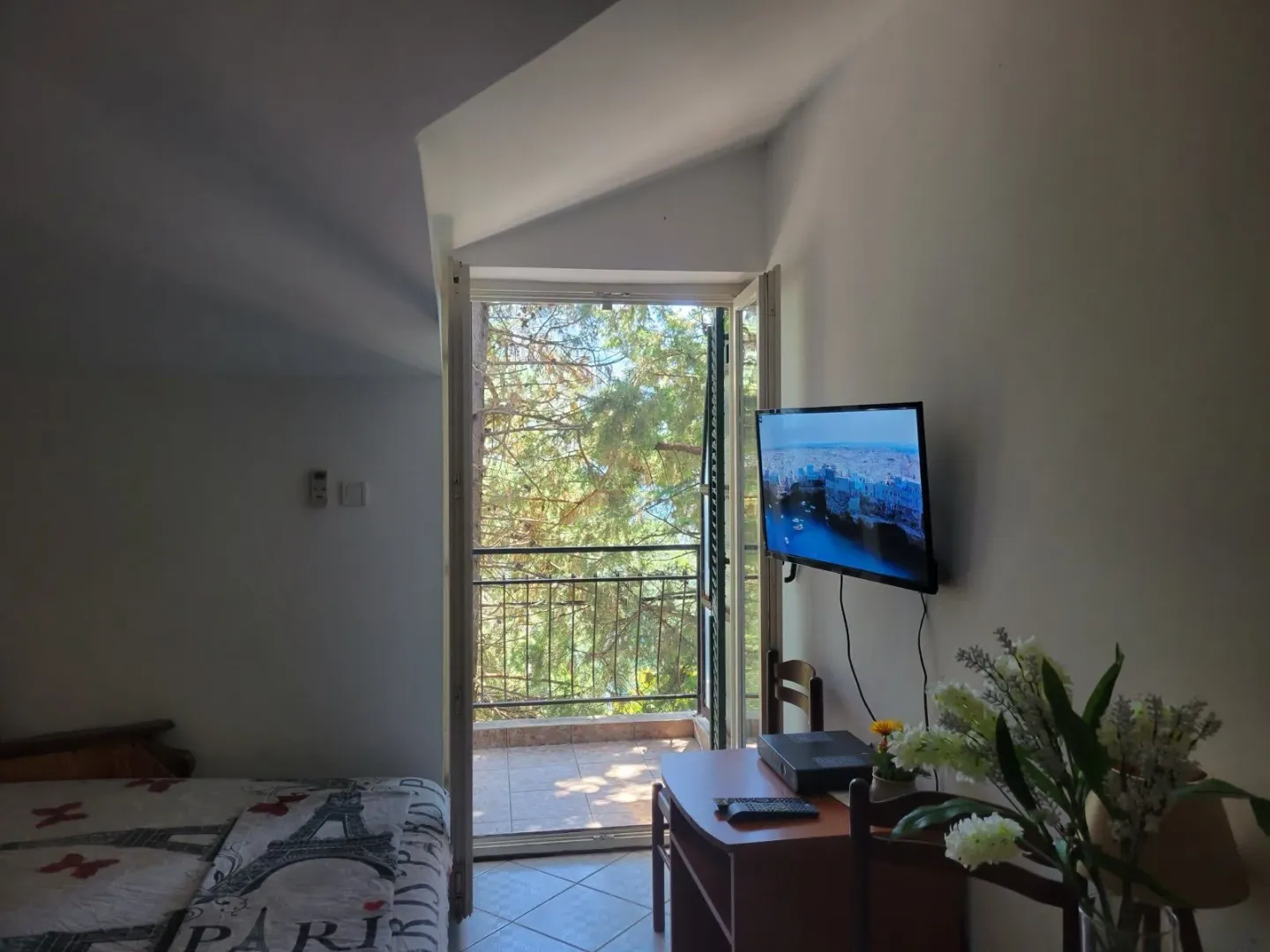 Bedroom with access to the terrace and a view of greenery.