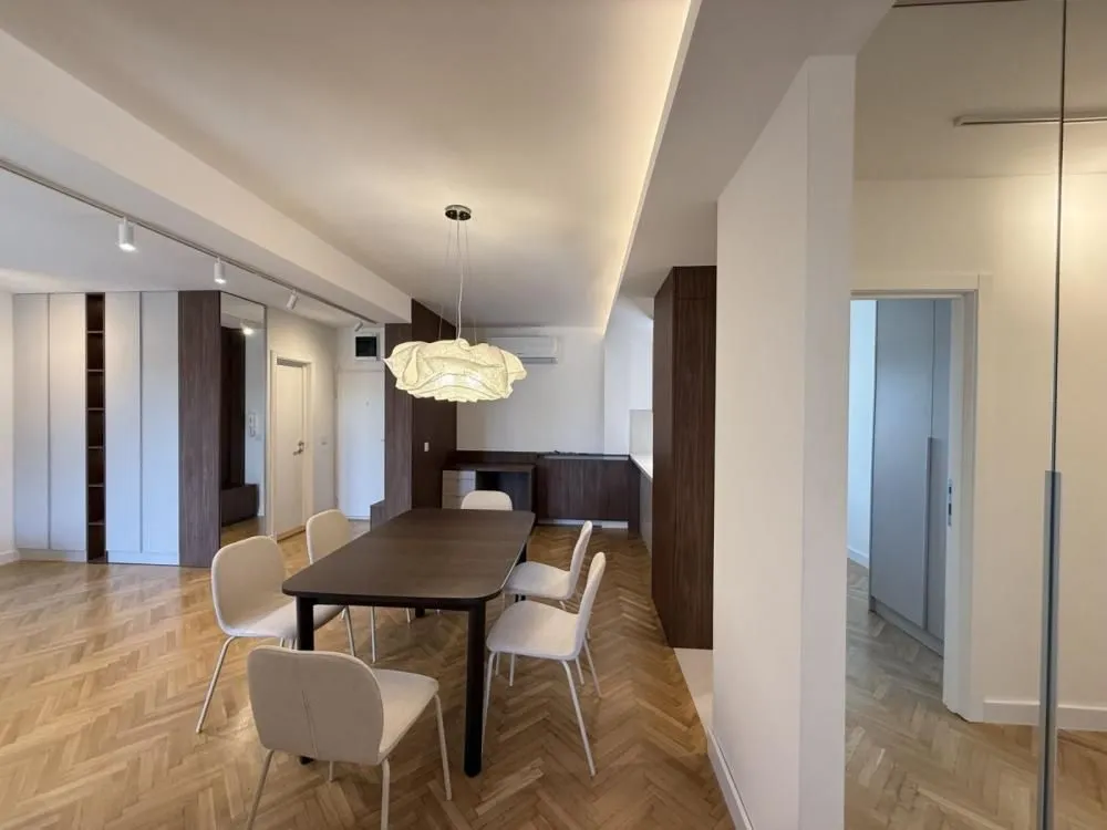 Dining area with a modern table and chairs, connected to the living room.