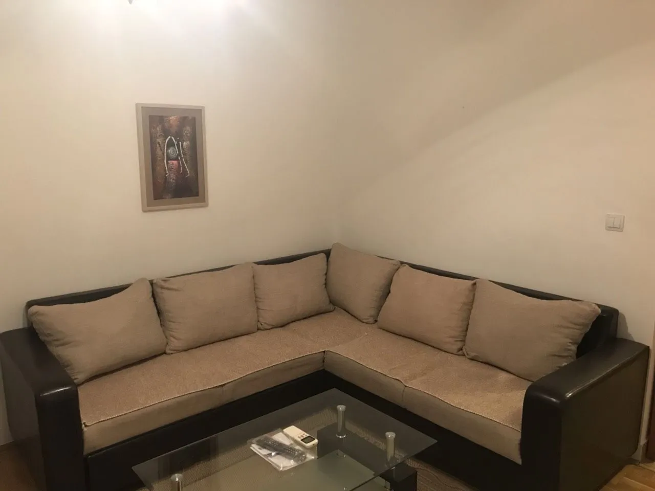 Ugaona garnitura u dnevnoj sobi sa staklenim klub stolom.