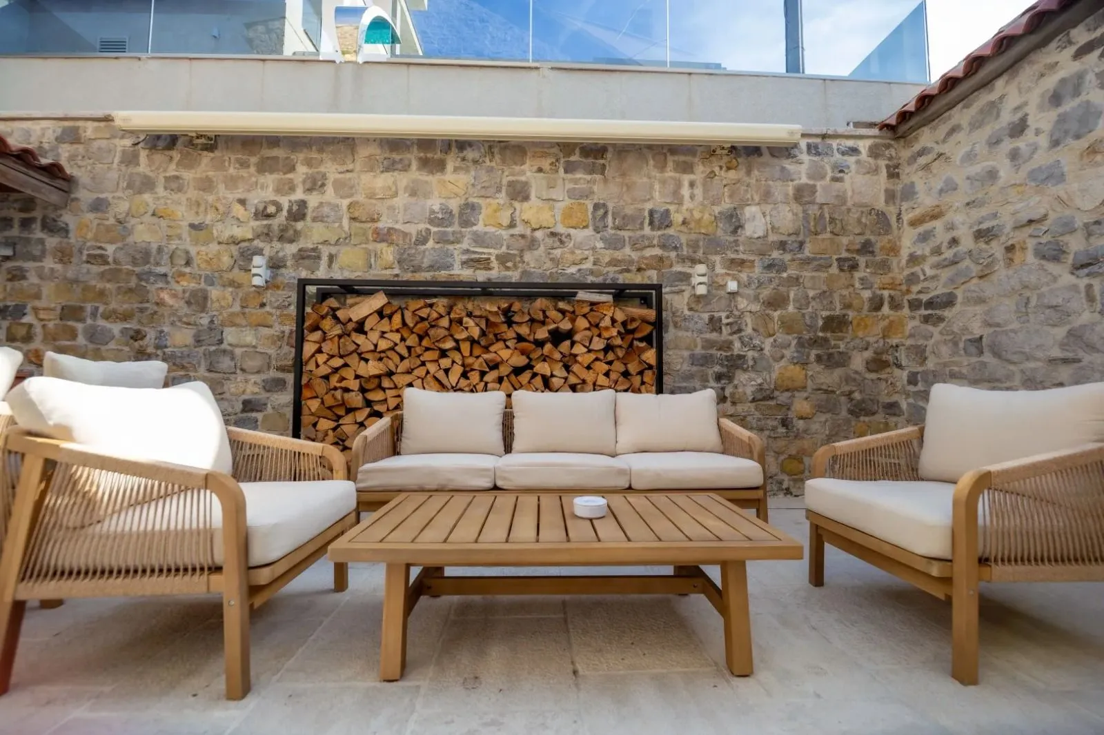 Lanscaped courtyard with outdoor seating furniture and a stone wall.