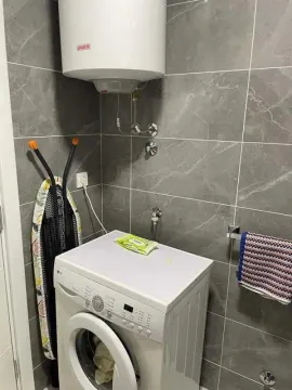 Kupatilo sa veš mašinom i bojlerom na zidu. - image 3