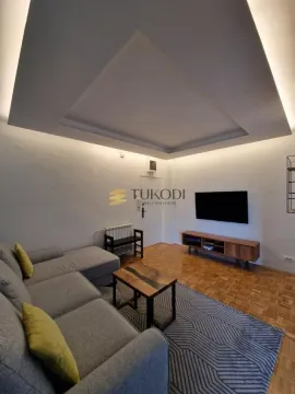 Living room with a sofa, television, and recessed ceiling lighting. - image 4