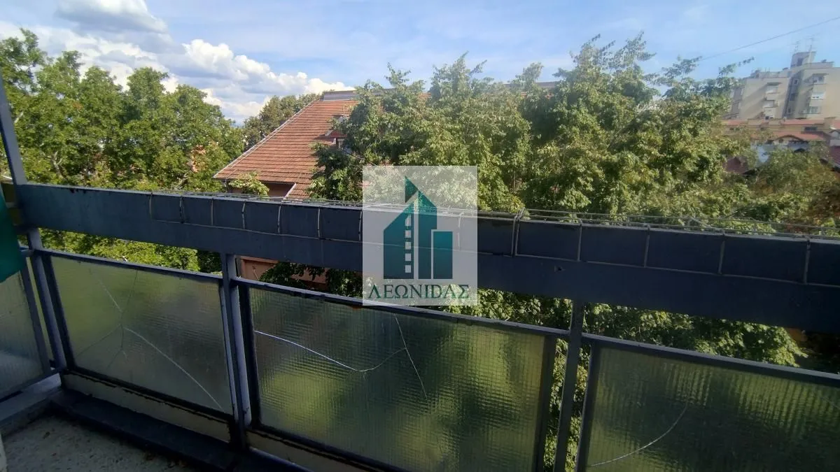 View from the balcony overlooking surrounding greenery and buildings.