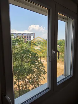View through the window of surrounding greenery and buildings. - image 2