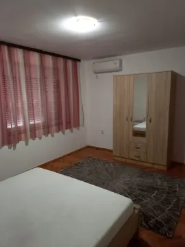A bedroom with a wooden wardrobe, bed, and a rug. - image 5