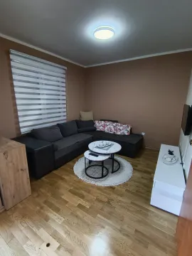 Comfortable living room with a corner sofa, coffee tables, and a television. - image 4