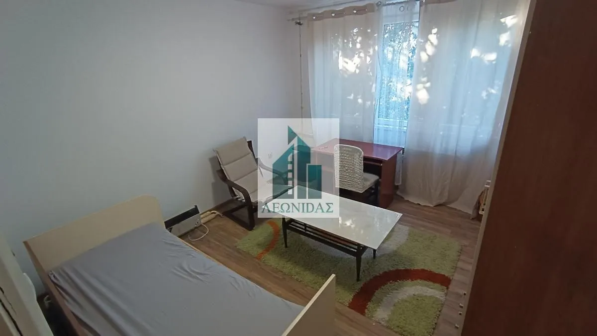 Furnished bedroom with a bed, desk, and rug.
