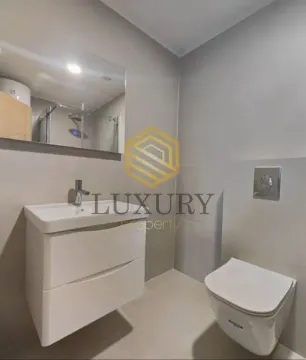 Modern bathroom with a washbasin, mirror, and toilet. - image 12