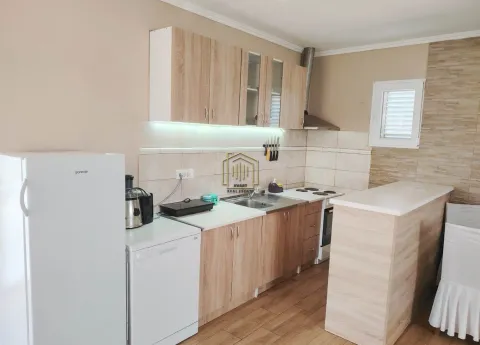 Smaller kitchen with wooden cabinets and built-in appliances. - image 4