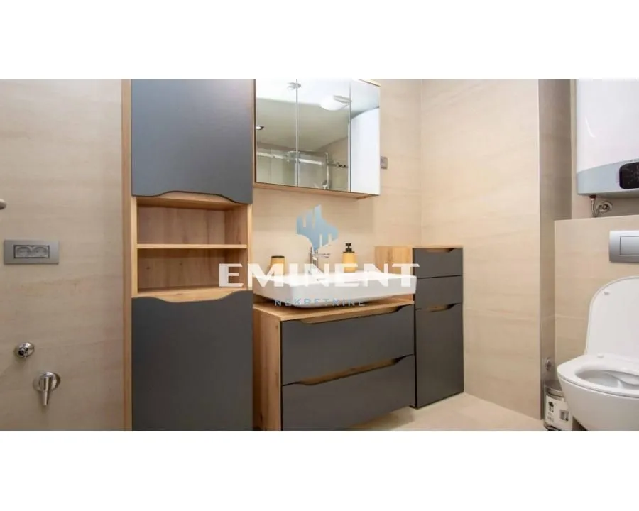 Modern bathroom equipped with a washbasin, cabinet, mirror, and toilet.