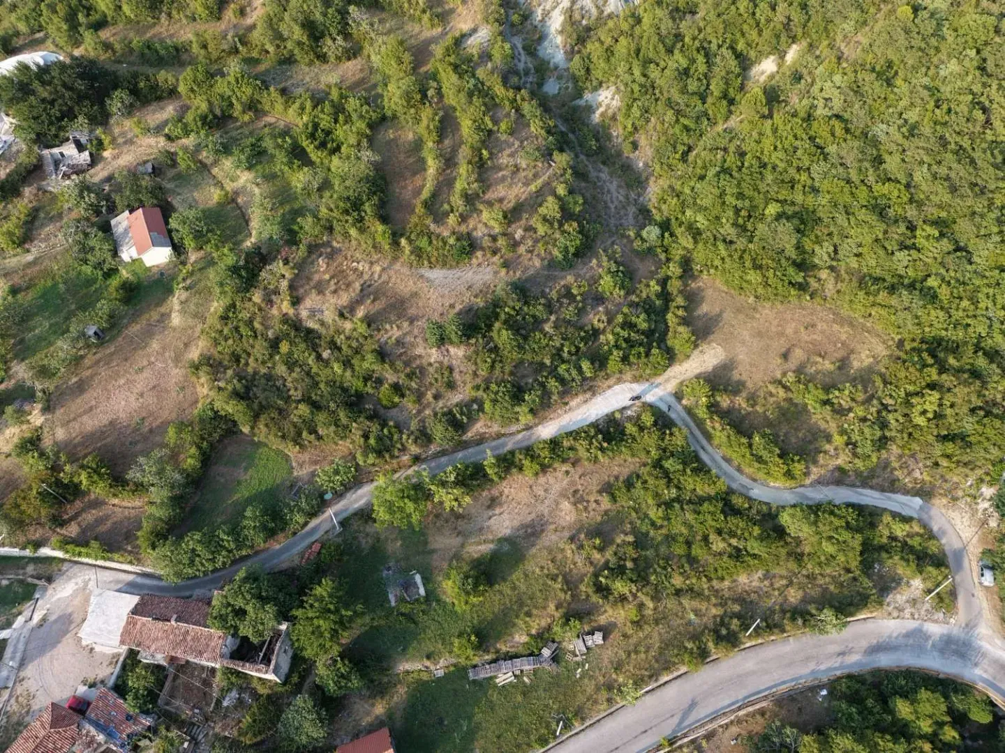 Pogled iz vazduha na zemljište sa zelenilom i pristupnim putem.