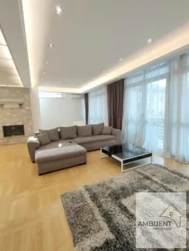 Spacious living room with a sectional sofa, fireplace, and large windows. - image 2