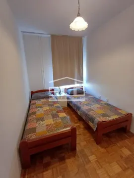 Bedroom with two single beds and parquet flooring. - image 3