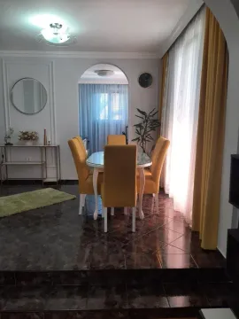 Dining area with a table, yellow chairs and a large window. - image 16
