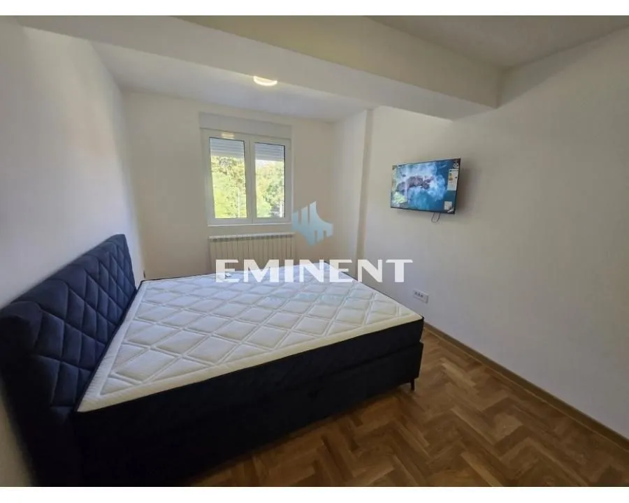 Bedroom with a double bed and a wall-mounted TV.