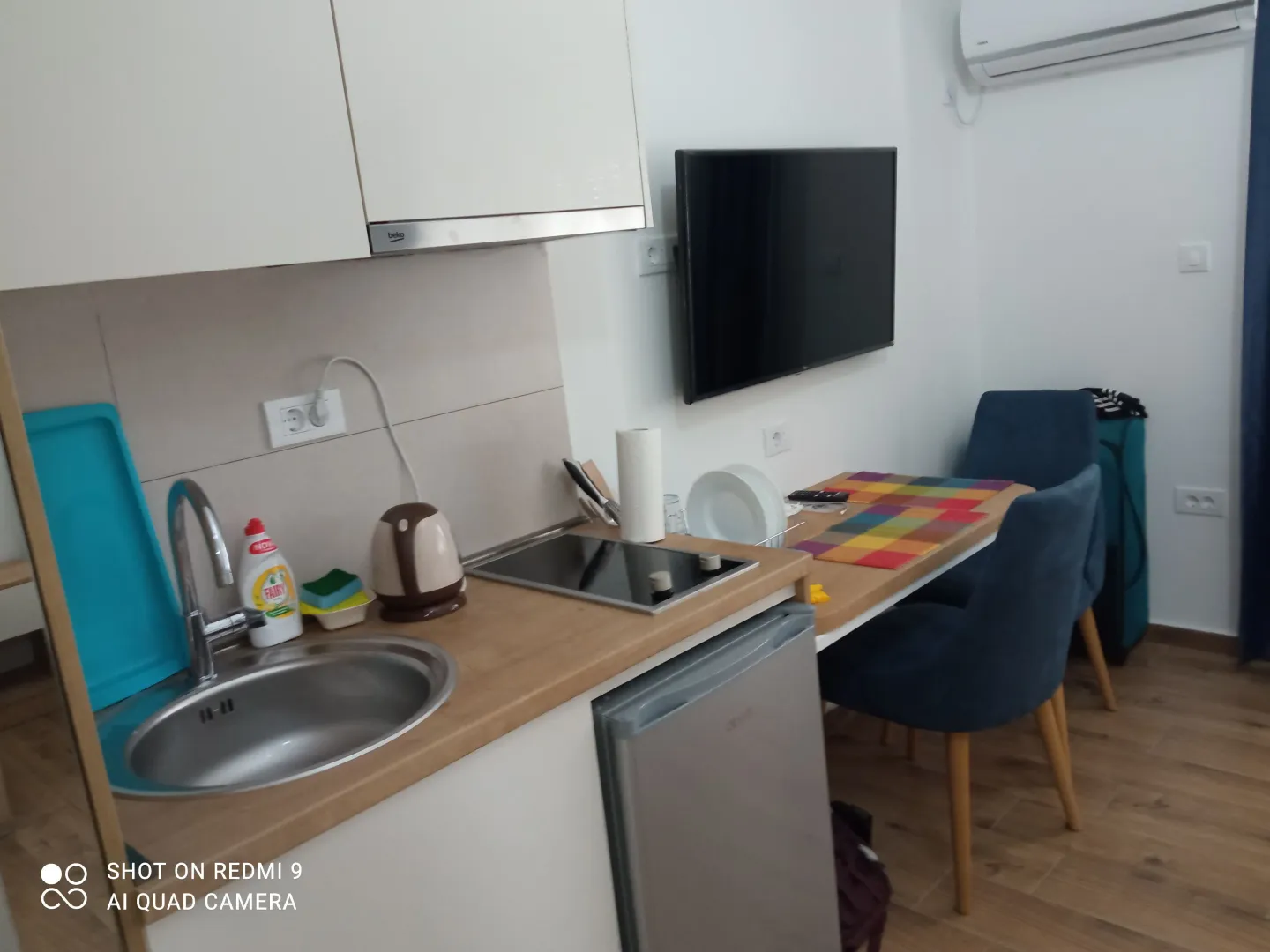 Small kitchen with a sink, built-in cooktop, and dining area.