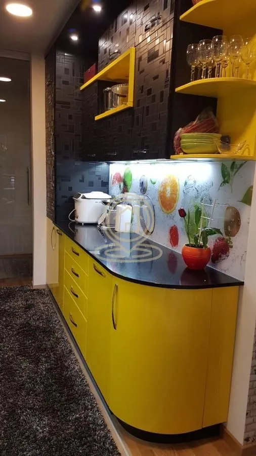 Modern kitchen with yellow lower cabinets and black upper cabinets.