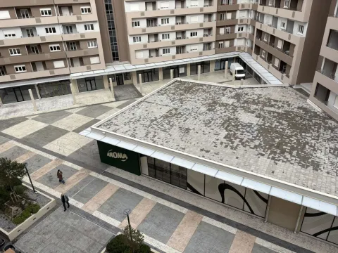 Pogled sa visine na popločano dvorište i fasadu modernog stambeno-poslovnog kompleksa. - image 8