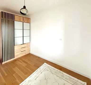 Furnished bedroom with a built-in wardrobe and wooden flooring. - image 11