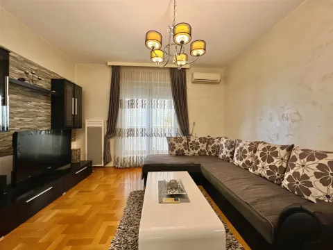 Spacious living room with a sectional sofa, TV unit, and hardwood flooring. - image 2