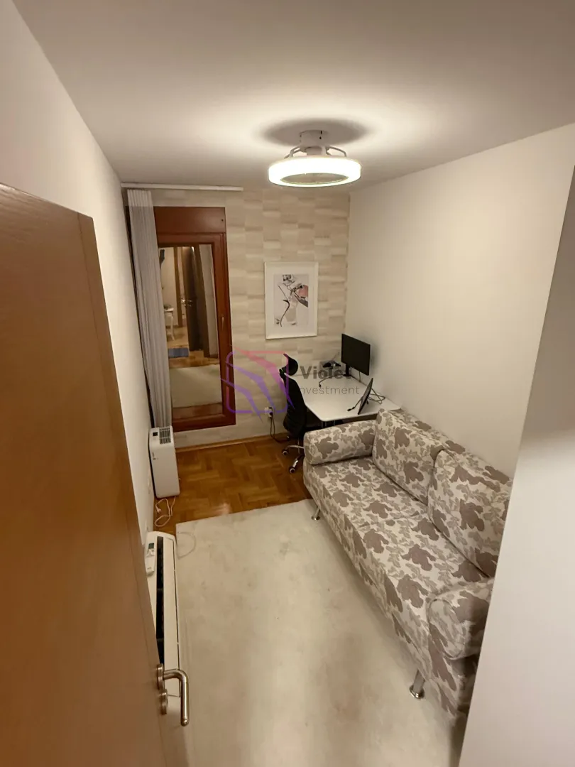 Manja dnevna soba sa garniturom na razvlačenje i radnim stolom.