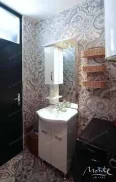 Kupatilo sa umivaonikom, ogledalom i ukrasnim pločicama na zidu. - image 16