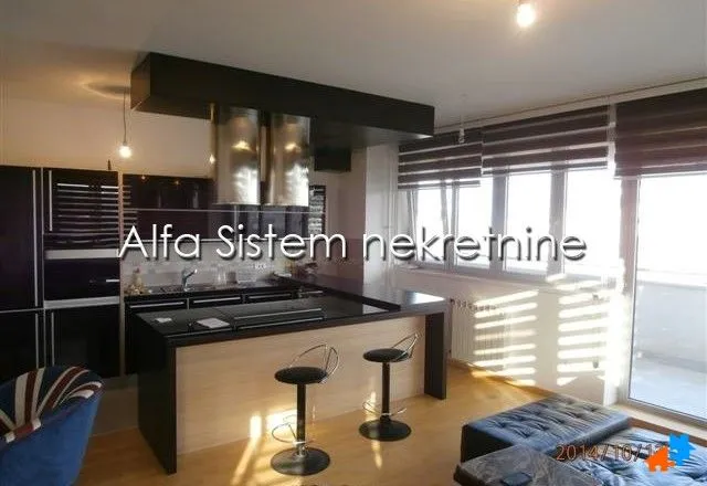 Moderna kuhinja sa šankom i trpezarijskim delom pored prozora.