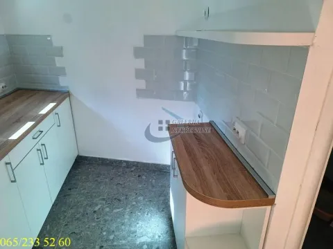 Small kitchen with white cabinets and grey wall tiles. - image 12