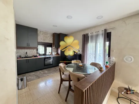 Modern kitchen with a dining area and dark cabinetry. - image 7