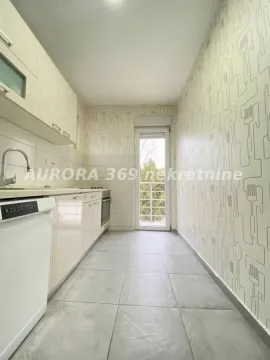 Dugačka kuhinja sa belim elementima i izlazom na terasu. - image 5