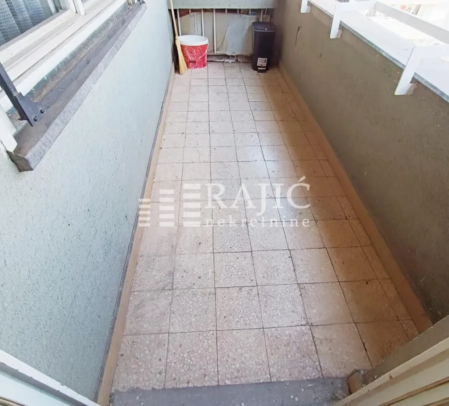 Small enclosed balcony with tiled flooring.