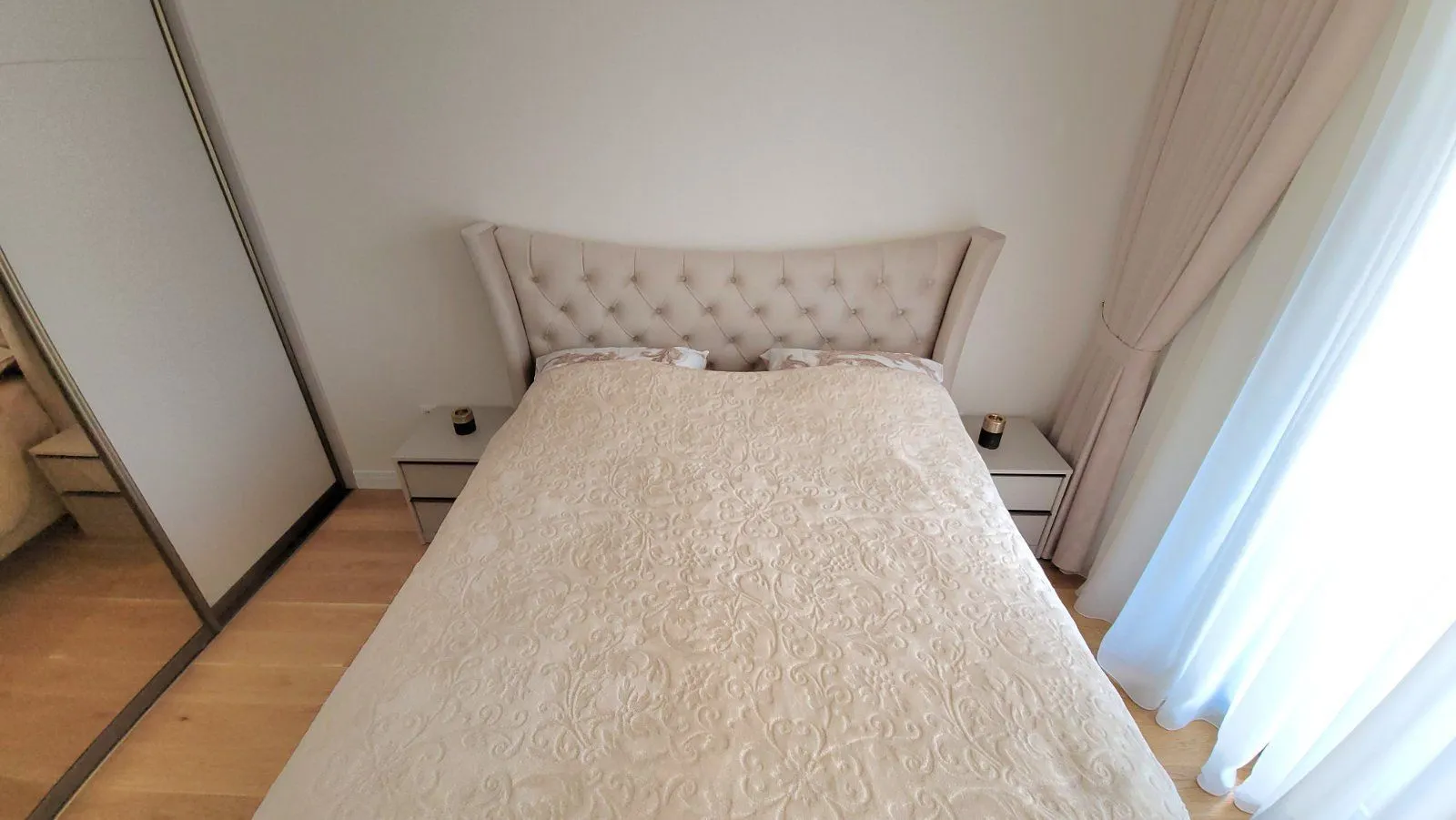 Bedroom with a double bed, nightstands, and a built-in wardrobe.