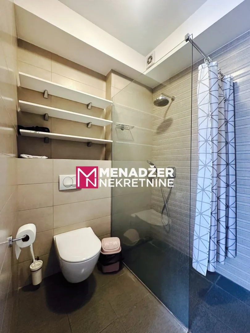 Modern bathroom with a walk-in shower and a wall-hung toilet.