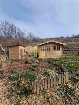 Drvena vikendica u dvorištu sa manjom ogradom i okolnim zelenilom. - image 4