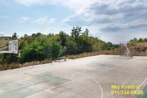 Outdoor sports court with basketball hoops surrounded by greenery. - image 15
