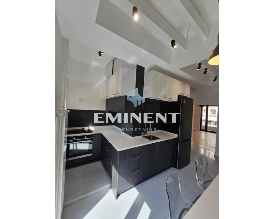 Modern kitchen with dark cabinetry and white countertops.