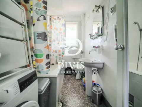 Smaller bathroom with a bathtub, washbasin, and washing machine. - image 17