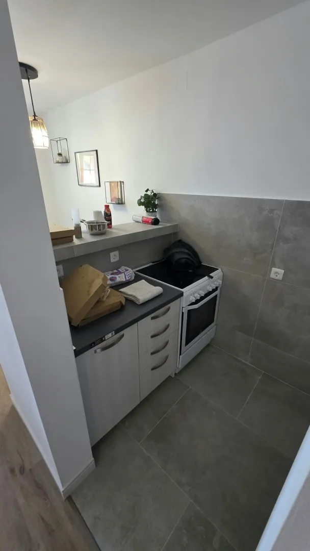 Small kitchen with cabinets and a stove.